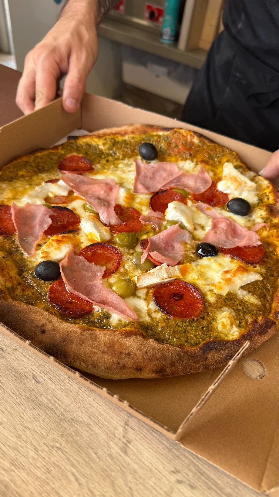 Pesto-base stone-baked pizza with bacon, portobello mushrooms and olives